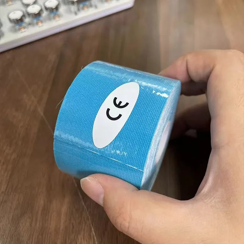 A hand holding a roll of light blue kinesiology sports tape with a CE certification sticker on the side.