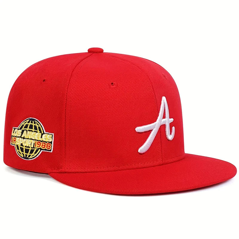 Red baseball cap with a white embroidered 'A' on the front and a gold globe graphic patch on the side.