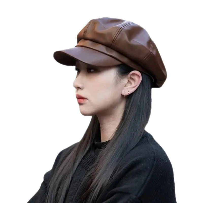 Side profile of a woman wearing a dark brown, faux leather newsboy-style baker boy cap with a structured peak.