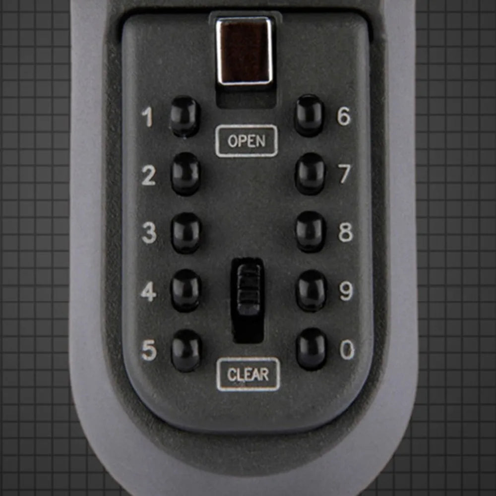 Grey metal wall-mounted key safe with a push-button numeric keypad, an Open button, and a Clear button.