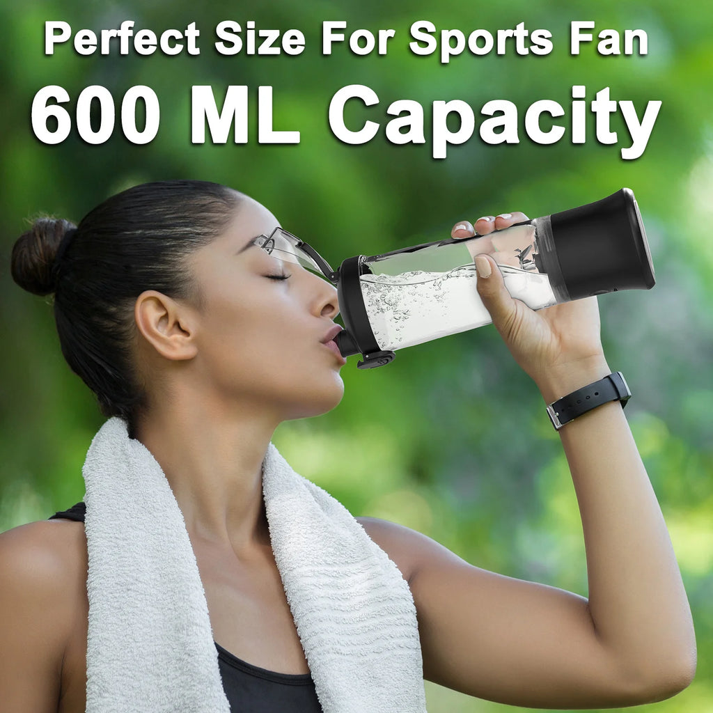 Woman drinking from a 600ml clear plastic sports bottle with a black lid and motor base against a green background.