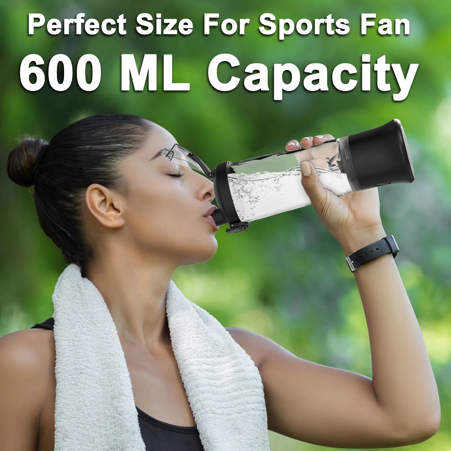 Woman drinking from a 600ml clear plastic sports bottle with a black lid and motor base against a green background.