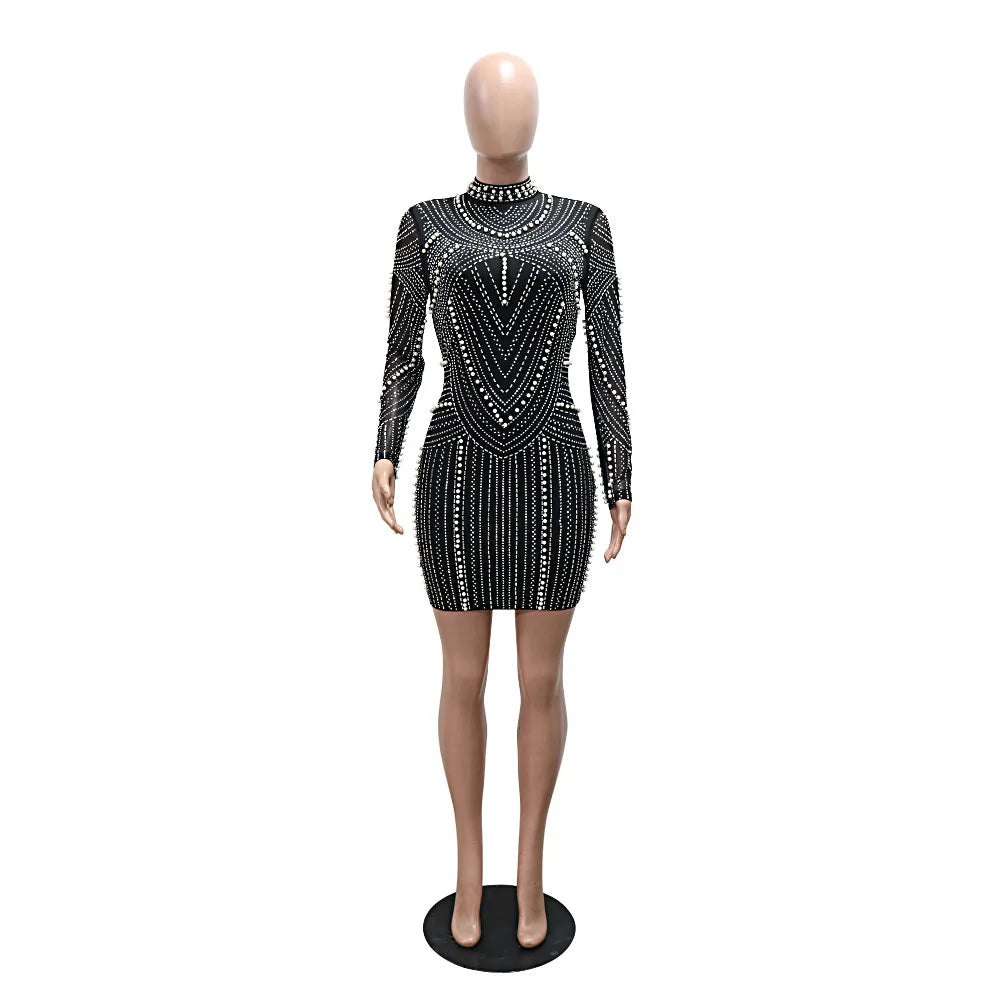 Black long-sleeve mini dress with mock neck, covered in intricate rhinestone and pearl patterns.