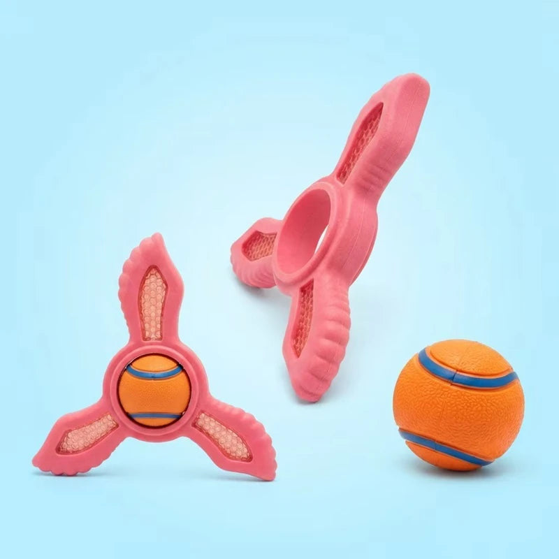 Pink three-pronged fetch rings and an orange ball with blue stripes on a light blue background.