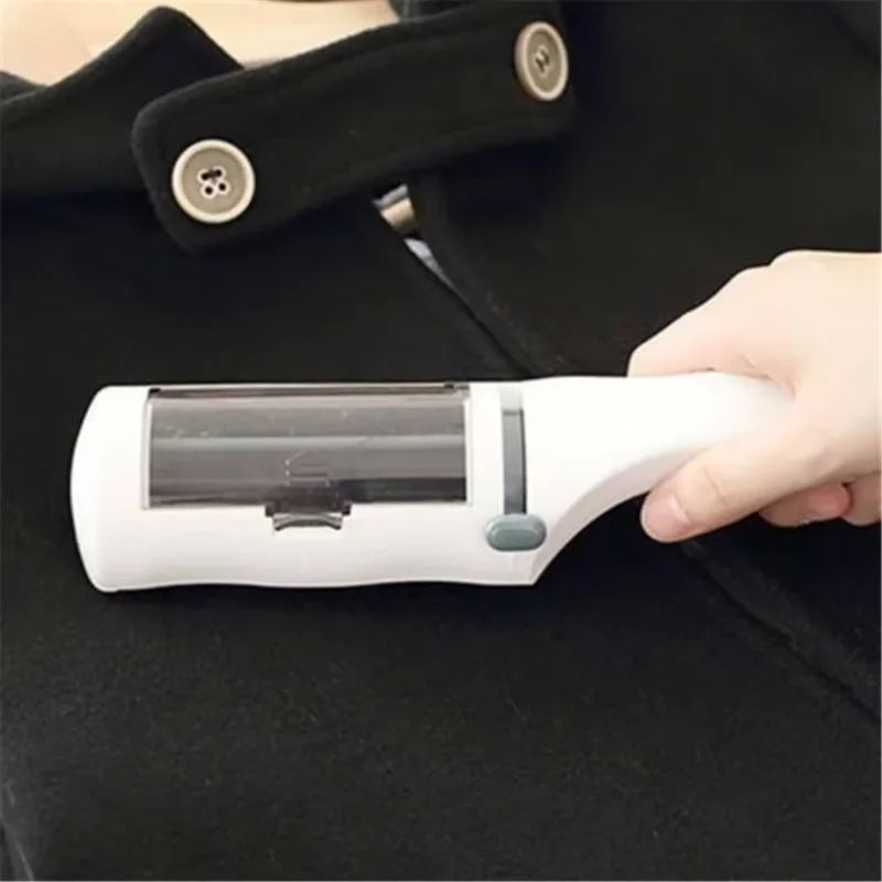 A white handheld lint remover being used on a black wool coat with visible light buttons.