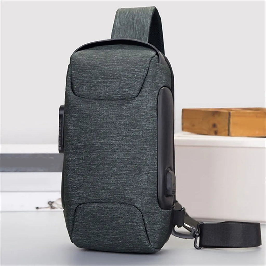 Dark grey, waterproof crossbody sling bag with a built-in USB charging port and adjustable shoulder strap.