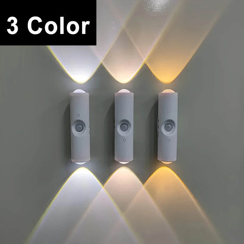 Three slim, white, motion-sensor wall lights glowing with cool white, neutral, and warm light settings.
