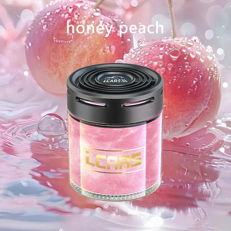Round, pink honey peach car air freshener with a sleek black vented lid and modern cylindrical glass design.