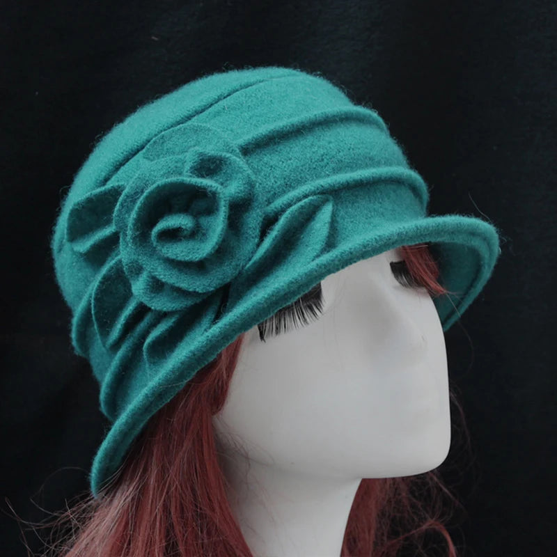Elegant teal green wool winter hat with pleated crown and a decorative felt flower on the side.