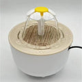 White pet water fountain with a daisy-shaped flower topper, wood-grain base, and flowing water.