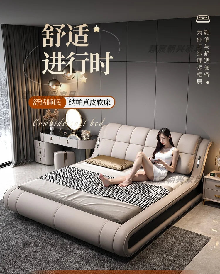 Modern beige leather bed frame with a sleek, curved silhouette and a tufted, cushioned headboard.