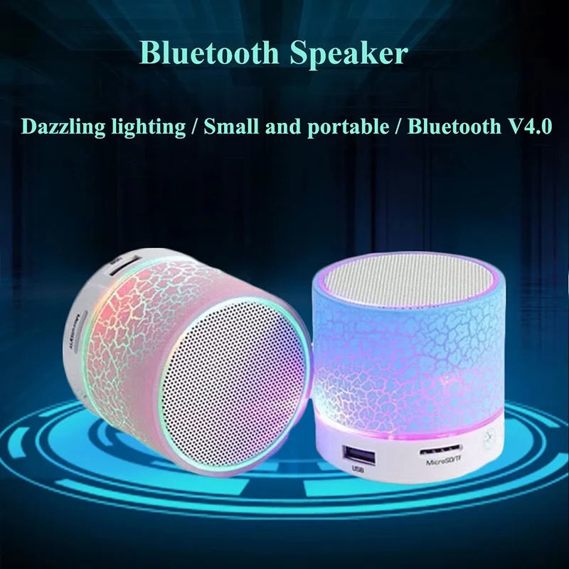 Two portable mini wireless speakers with crackle-effect LED glowing bodies and white speaker grilles.