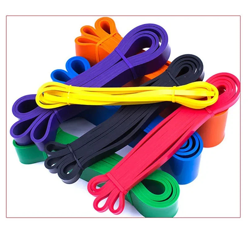 A collection of multi-coloured resistance exercise bands in various thicknesses, stacked on a white background.