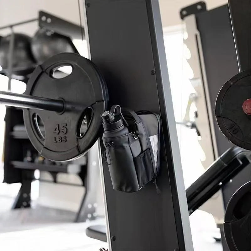 Black magnetic gym bottle holder attached to a squat rack, holding a matching black water bottle.