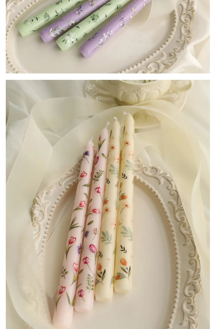 Set of taper candles in pastel pink, yellow, lilac, and green, featuring delicate floral and botanical patterns.