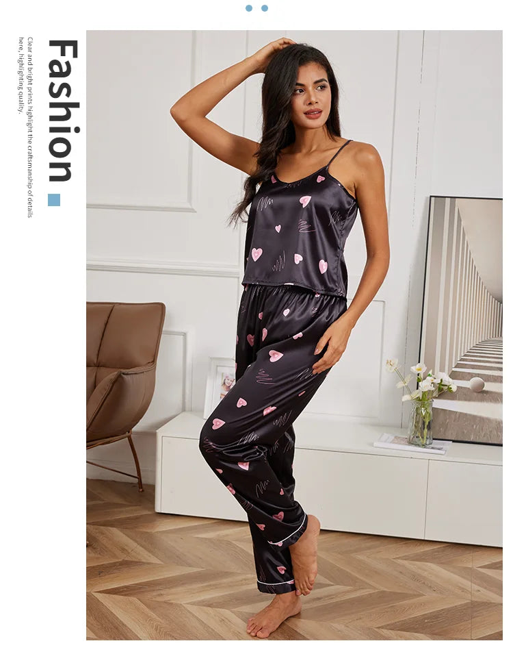Black satin pyjama set with camisole top and matching trousers, featuring a pink heart and scribble print.