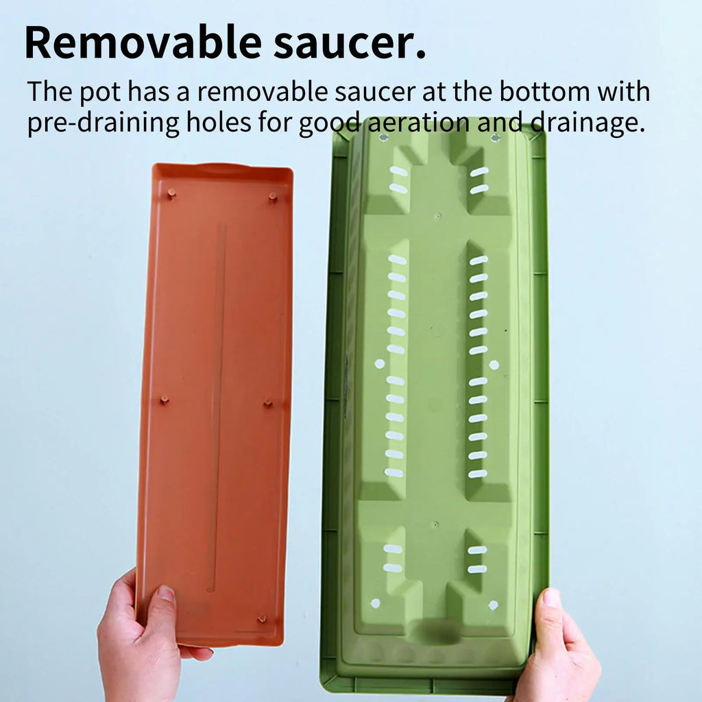 Hands hold a rectangular green planter base with drainage slots and a separate brown removable saucer tray.