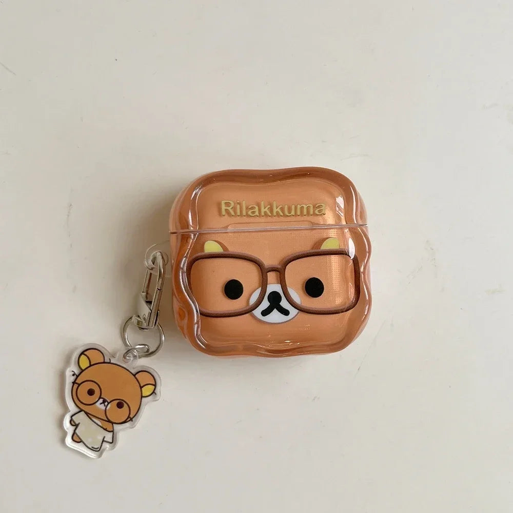 Clear plastic Rilakkuma AirPods case in beige with bear charm and glasses design. Compatible with AirPods Pro.