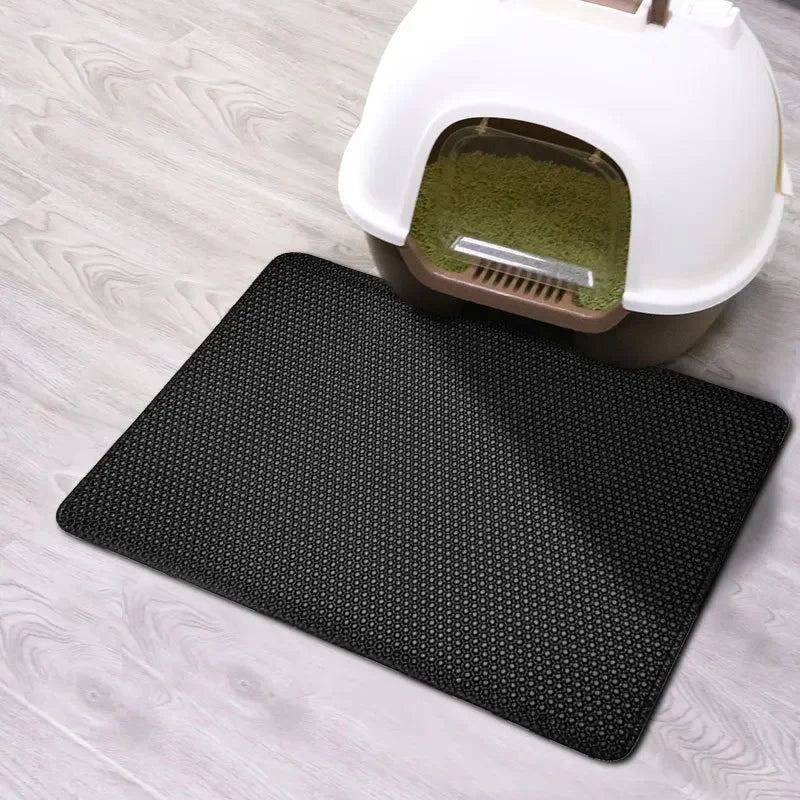 Black rectangular, double-layer cat litter mat with a non-slip, honeycomb texture placed in front of a litter tray.
