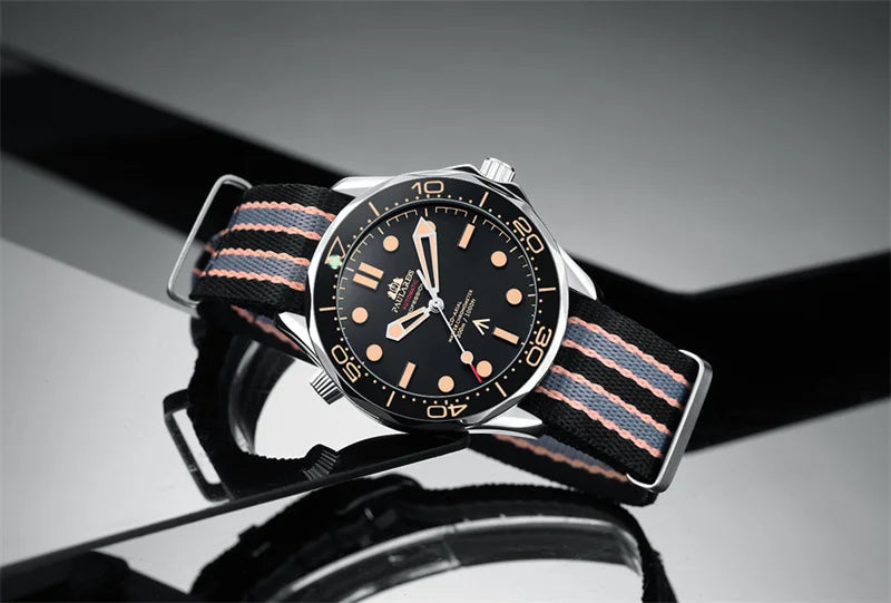 Men's stainless steel automatic watch with a black dial and a striped black, grey, and orange fabric strap.
