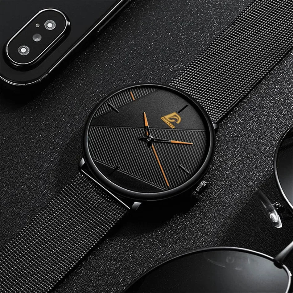 Minimalist men's ultra-thin quartz watch with a black mesh strap, textured black dial, and orange hands.