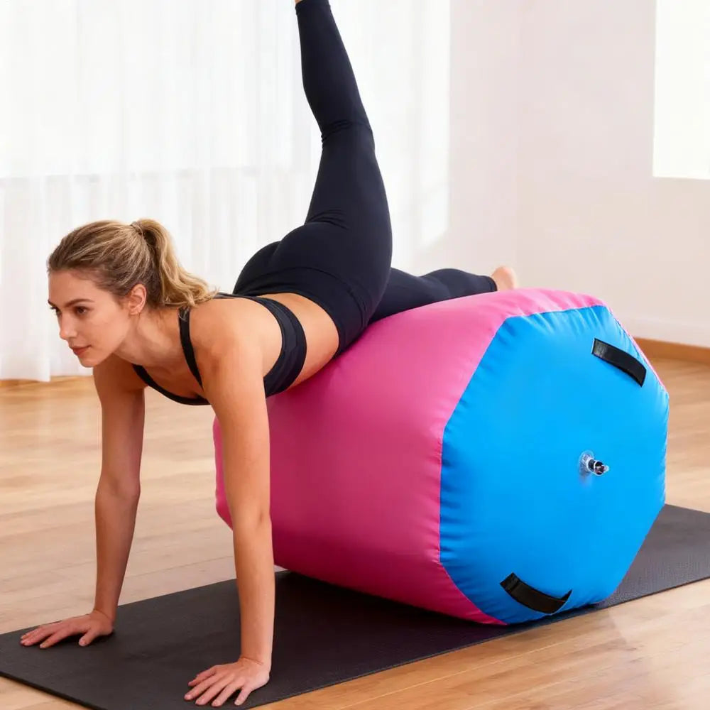 Woman exercising on a pink and blue inflatable gymnastics air roller barrel on a floor mat.