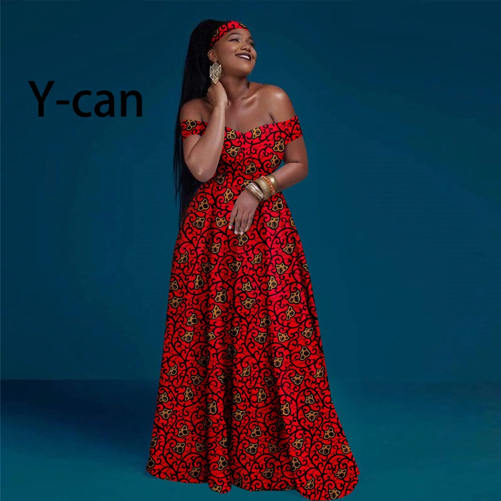 Model wearing an off-shoulder, floor-length red dress with black and yellow floral print and matching headband.