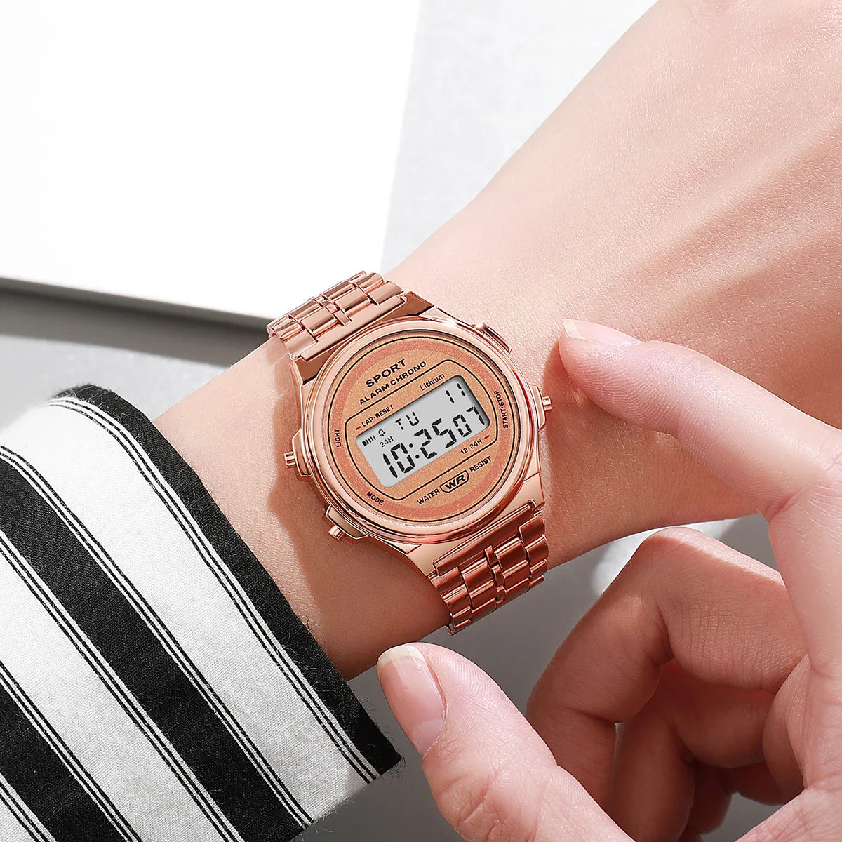 A rose-gold retro-style digital watch with a matching metallic link strap, worn on a wrist.