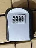 Black and grey plastic wall-mounted key lock box with a four-digit combination code dial.