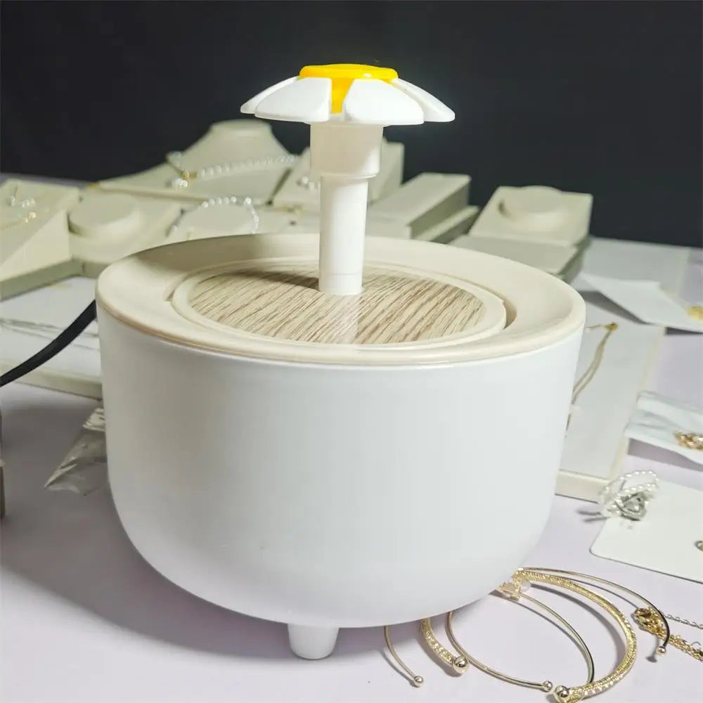 White pet water fountain with a wood-grain top and a yellow and white flower-shaped spout.