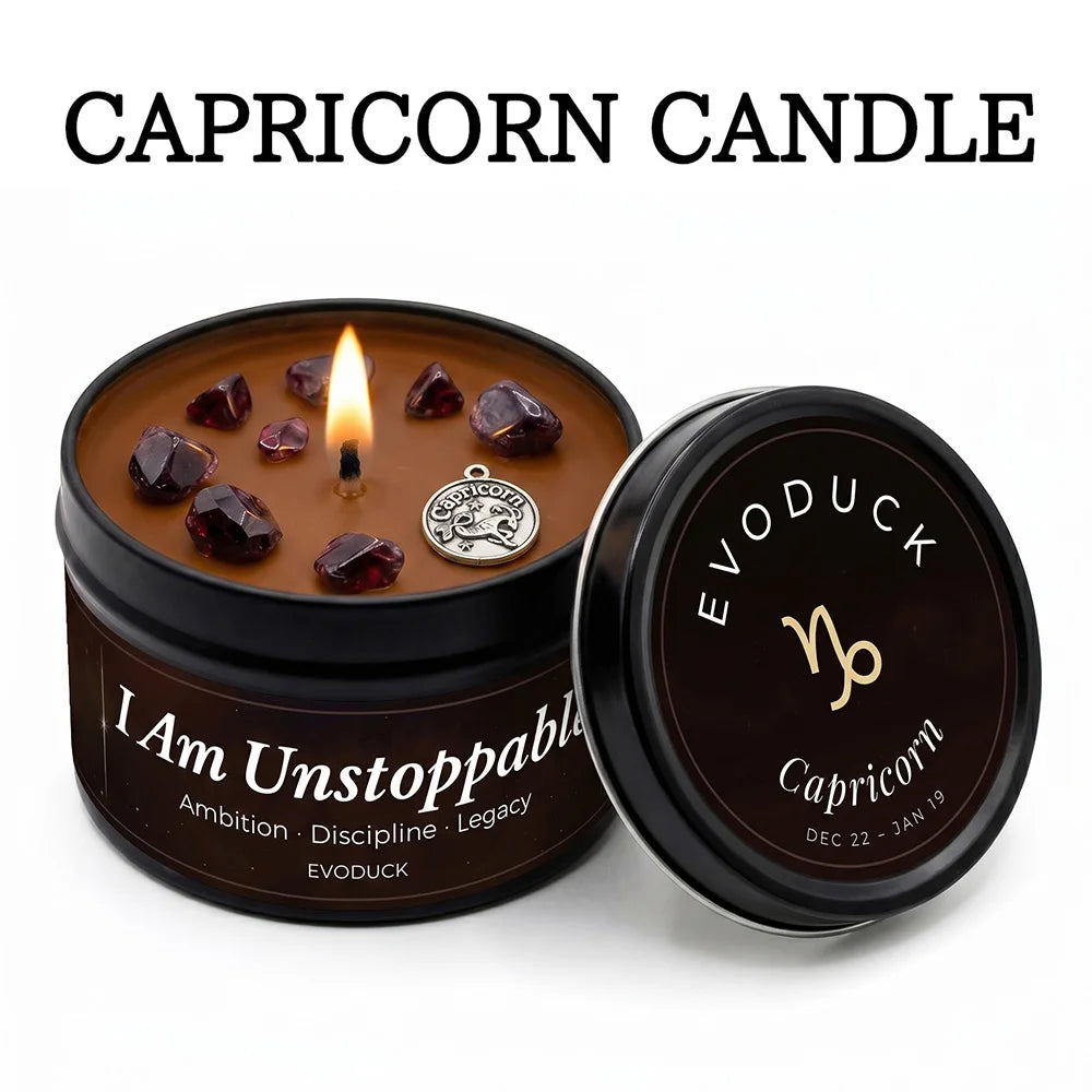 Lit Capricorn zodiac candle in a black tin, featuring brown wax, embedded crystals, and a silver Capricorn charm.