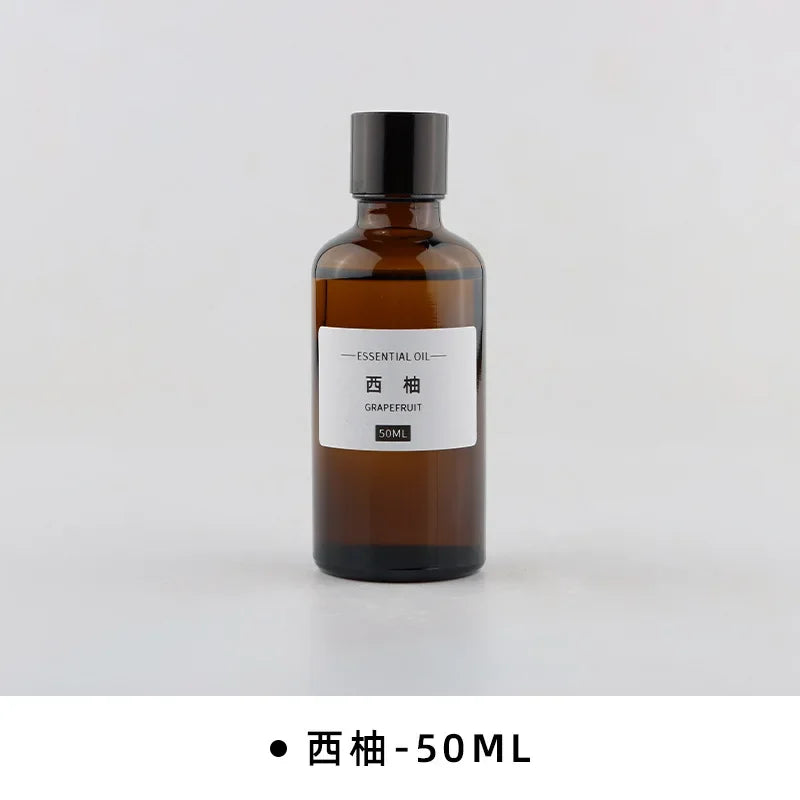 50ml amber glass bottle of grapefruit essential oil with a black screw cap and minimalist white label.