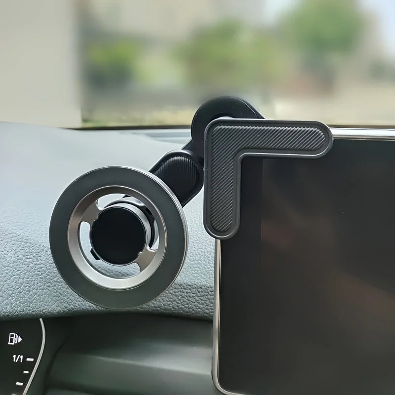 Black car phone mount with a circular base and L-shaped corner grip holding a mobile device on a vehicle dashboard.