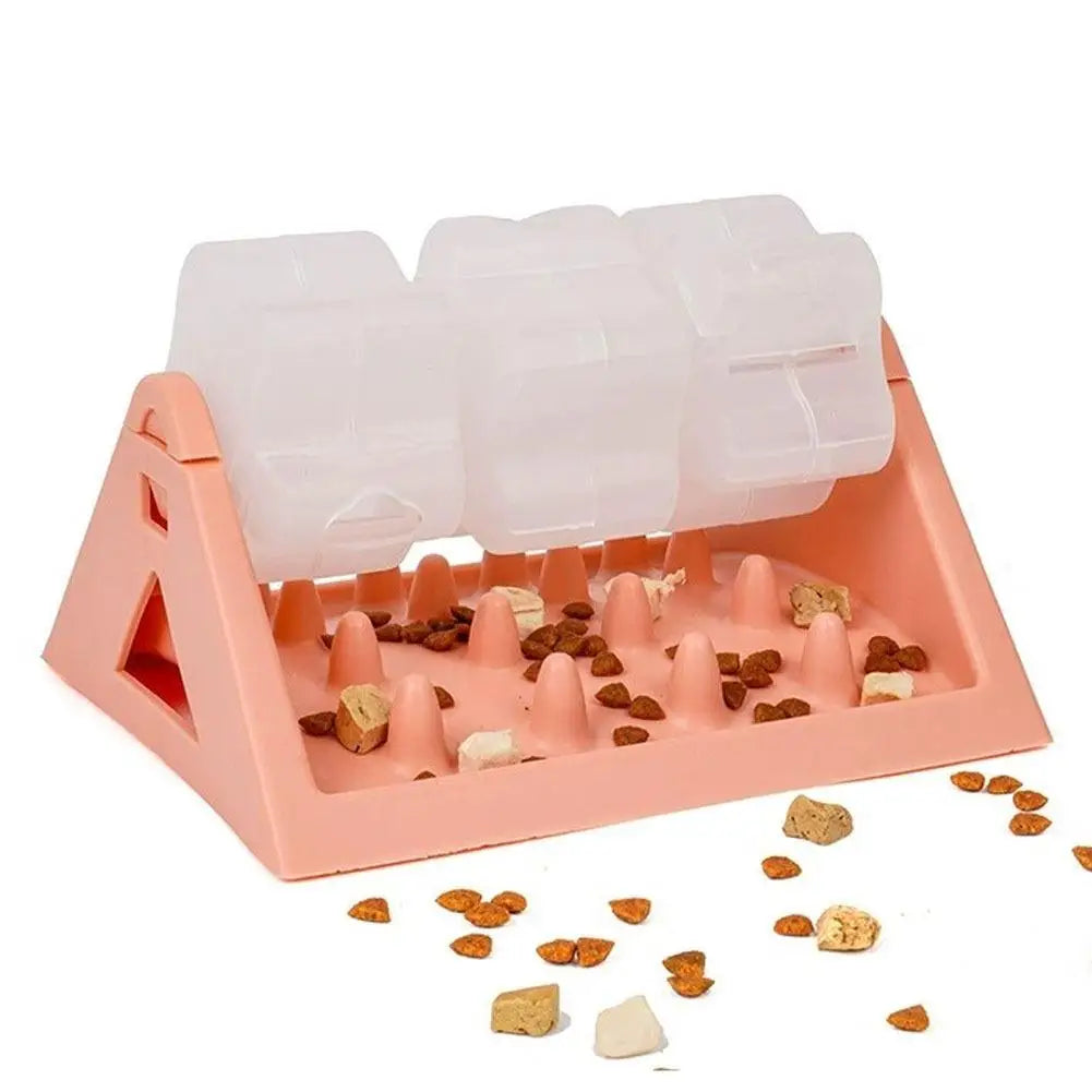 A peach-coloured interactive dog puzzle feeder with three clear spinning treat dispensers above a spiked slow-feeder base.