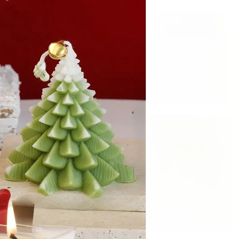 Green, tiered Christmas tree-shaped candle with a snowy white top and a small gold bell detail.