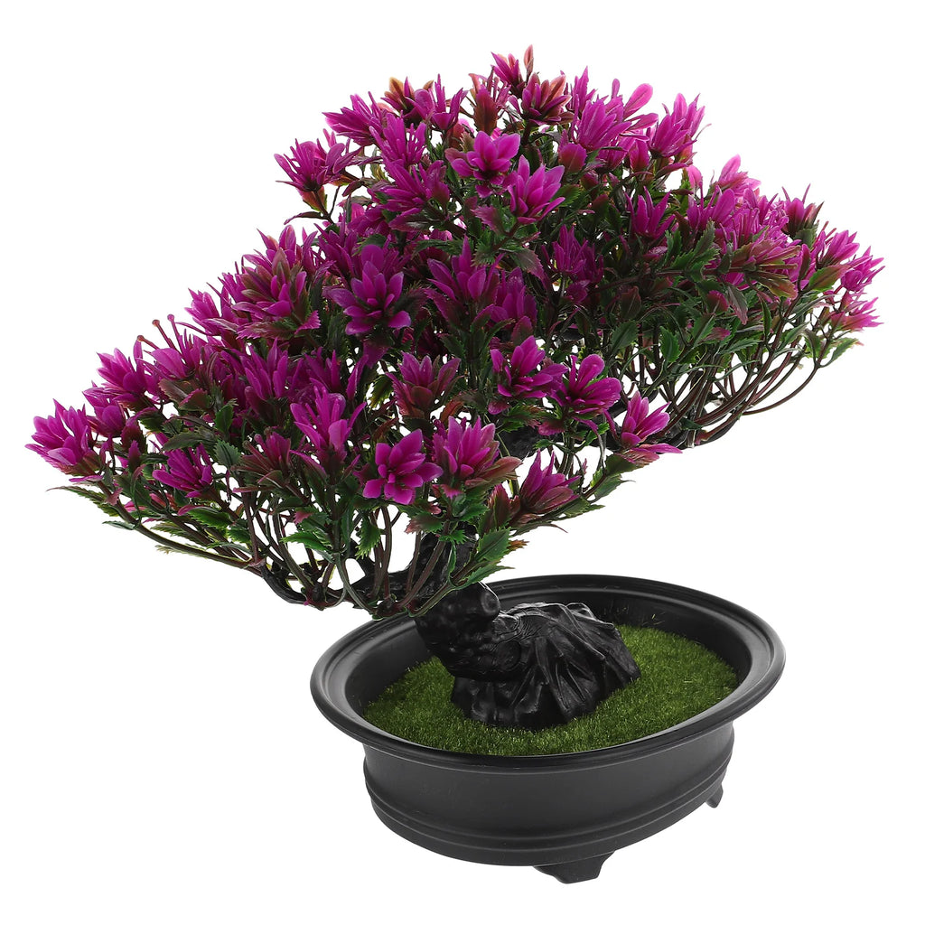 Artificial bonsai tree with vibrant magenta leaves, dark twisted trunk, and green faux moss in a black oval pot.