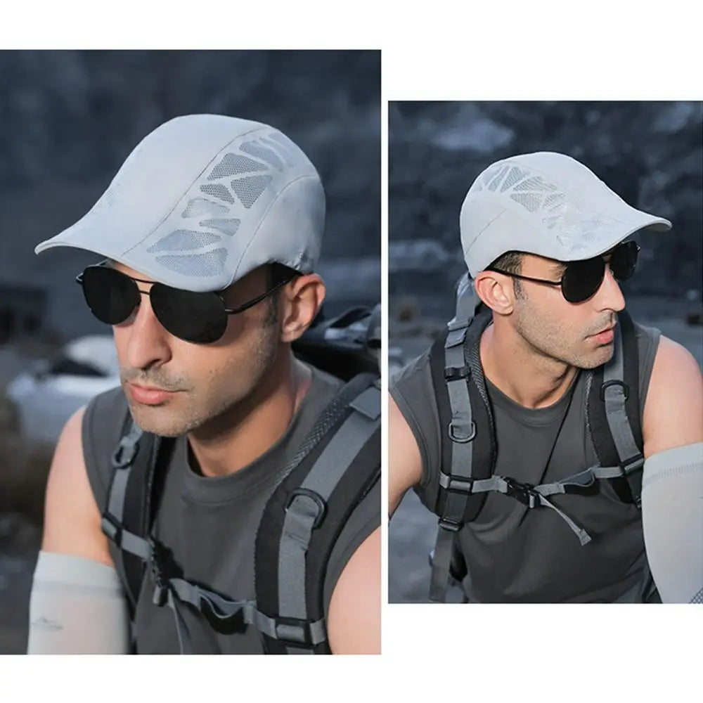 Light grey men’s flat cap featuring breathable mesh side panels, worn by a man in sunglasses and a backpack.