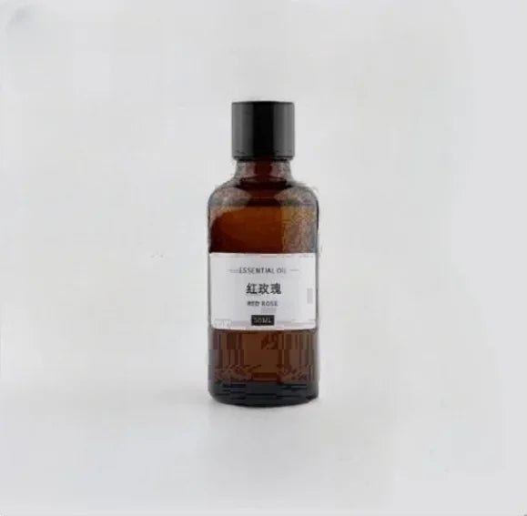 50ml amber glass bottle of Red Rose essential oil with a black screw cap and simple white label, isolated on white.