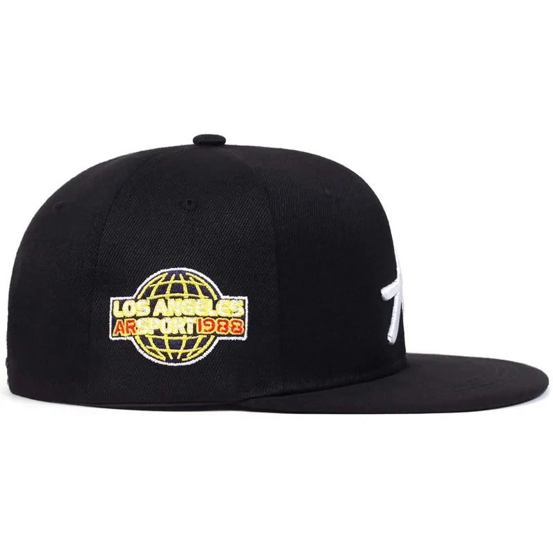 Black baseball cap with a white gothic letter and an embroidered globe graphic featuring 'Los Angeles' text.