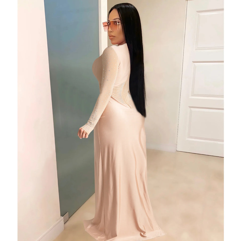 Nude sheer mesh long-sleeve jumpsuit with rhinestone patchwork and fitted form.