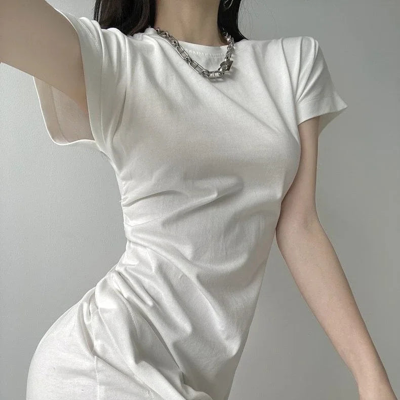 White short-sleeve fitted jersey dress with a side-ruched detail, paired with a chunky silver chain necklace.