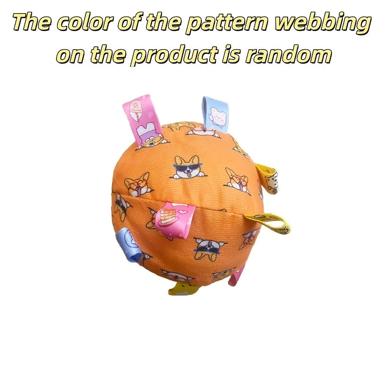 Orange interactive dog ball featuring a cute dog pattern with colourful fabric tabs protruding from the sides.