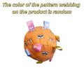 Orange interactive dog ball featuring a cute dog pattern with colourful fabric tabs protruding from the sides.