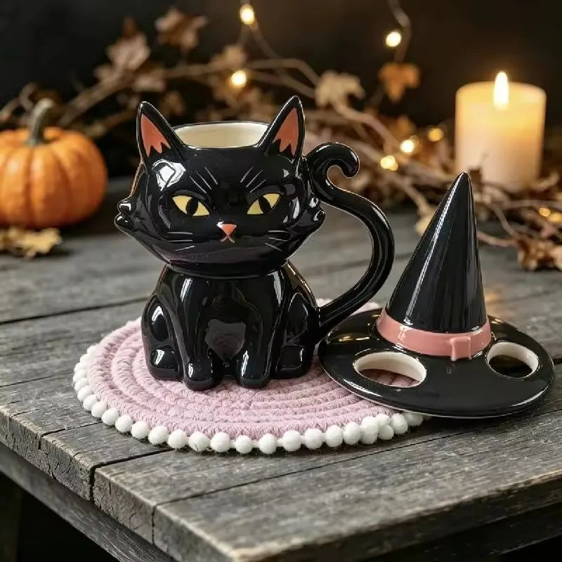 Glossy black ceramic cat mug with yellow eyes, curved tail handle, and a matching witch hat lid.