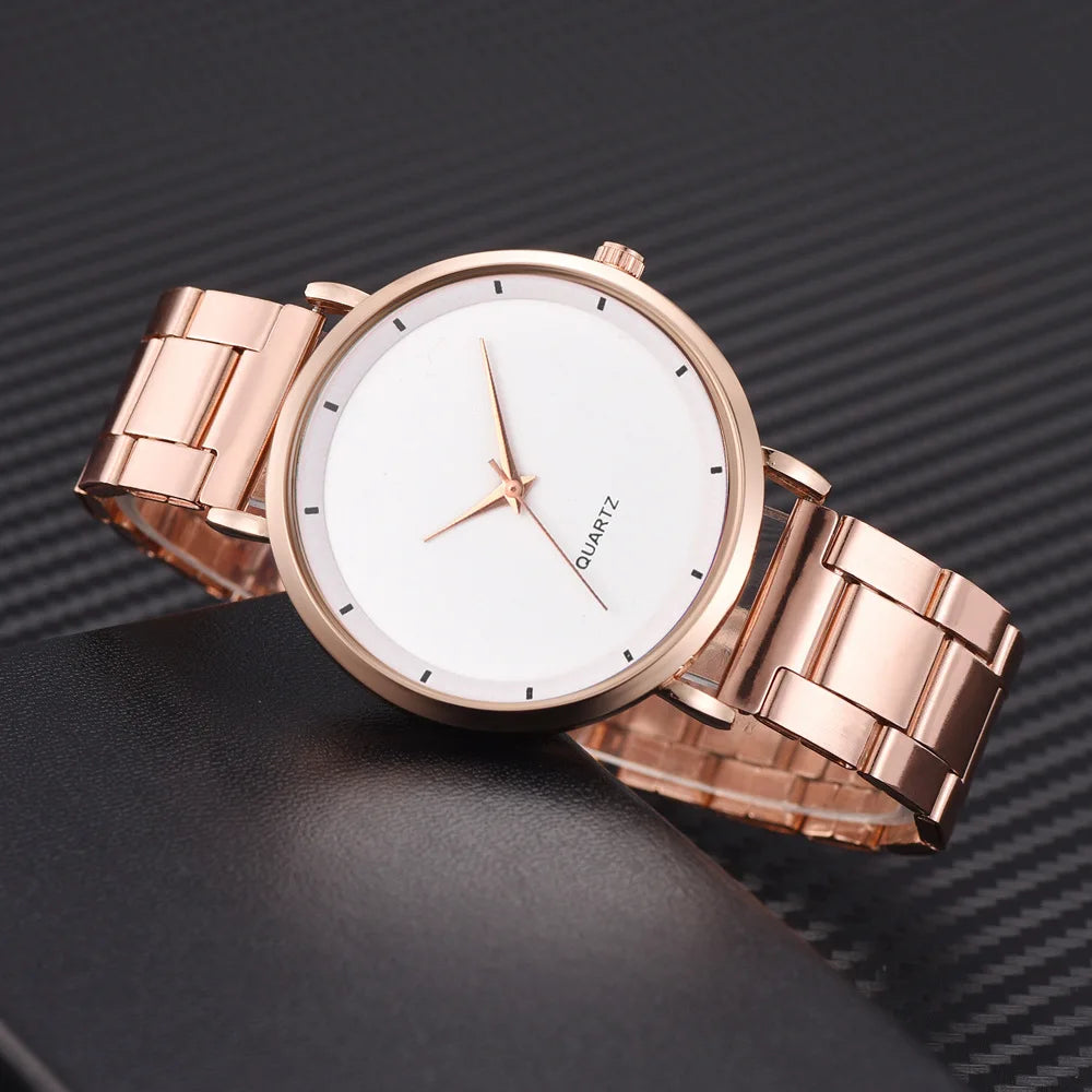 Ladies' rose gold stainless steel watch with a minimalist white face, slim hands, and a polished link strap.