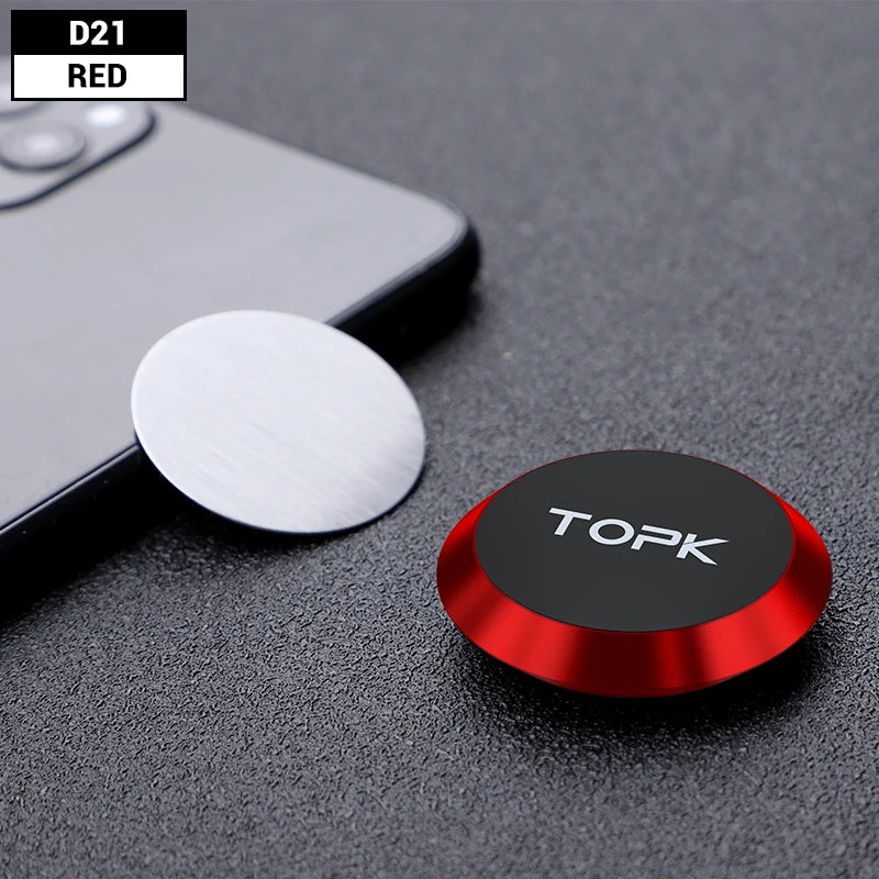 A red circular magnetic phone mount next to a silver metal adhesive disc on a textured black surface.