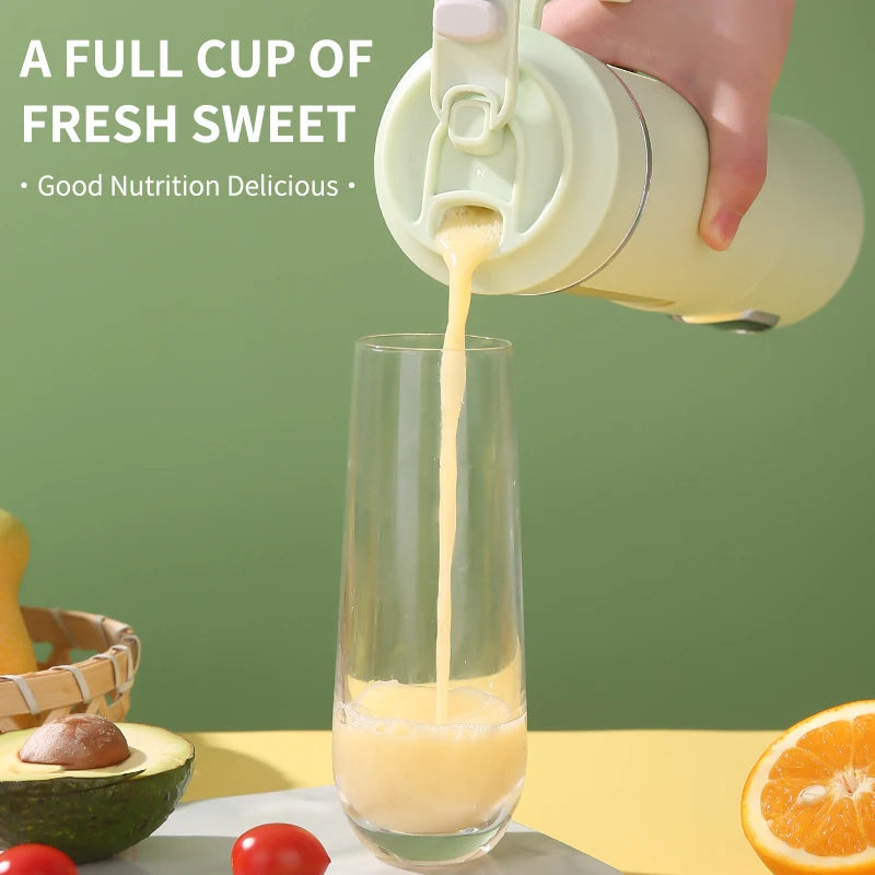 A hand pours fresh orange juice from a light green, modern portable blender into a tall glass on a yellow table.
