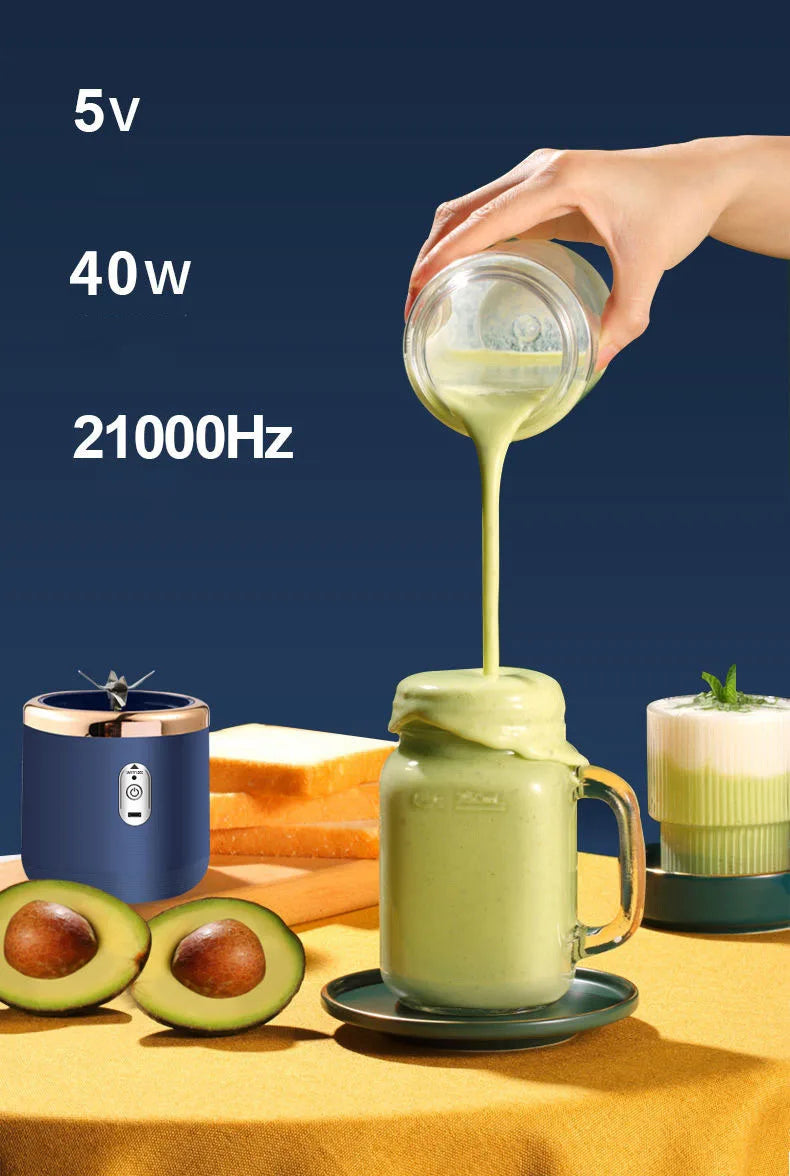 A navy blue portable blender with a gold rim and button, shown with a green avocado smoothie being poured into a mug.