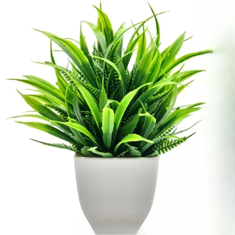 Vibrant green artificial grass and fern plant in a simple, matte white rounded plastic pot against a white background.