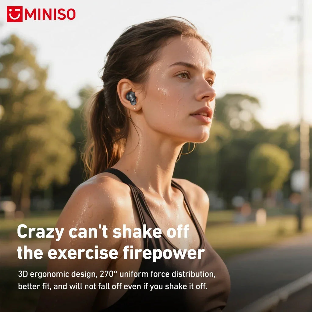 A woman wearing sleek black, ergonomic wireless earbuds while exercising outdoors in a park.